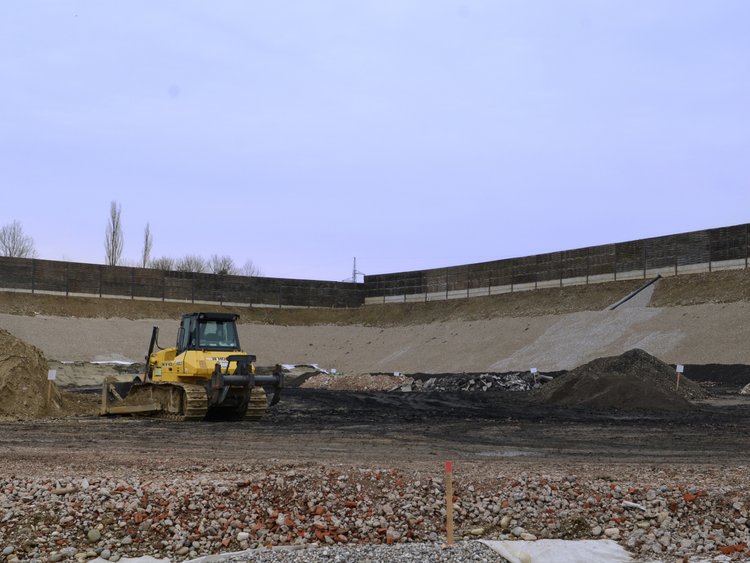 Photo: Landfilling wastes: Crawler-type loader in a rectangular pit lined with gravel and foils 