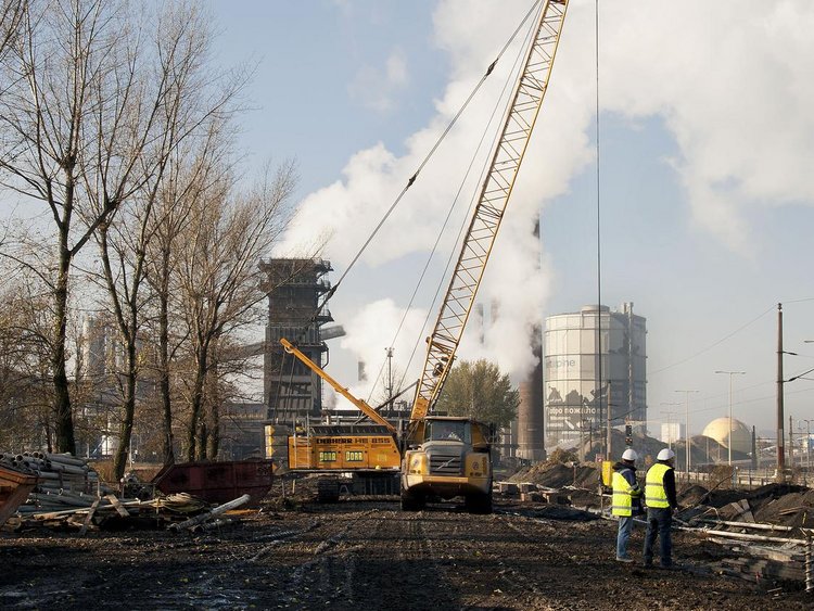Photo: Linz coke plant: view of the remediation site; two workers in the foreground and a large excavator crane in the background 